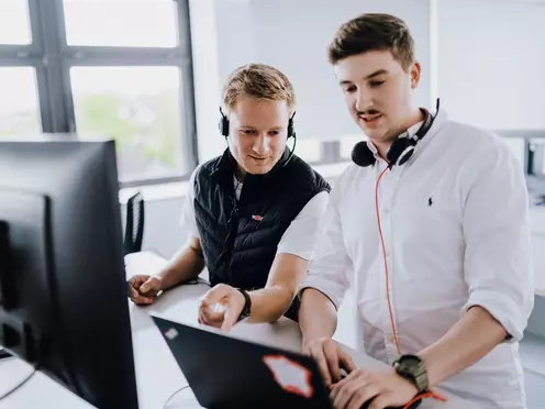 Mitarbeiter mit Headset und Laptop beim Arbeiten