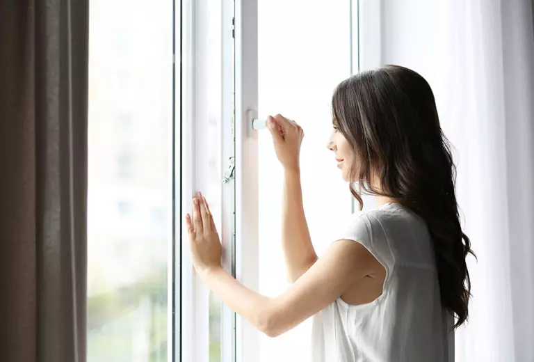 Richtig Lüften Frau am Fenster